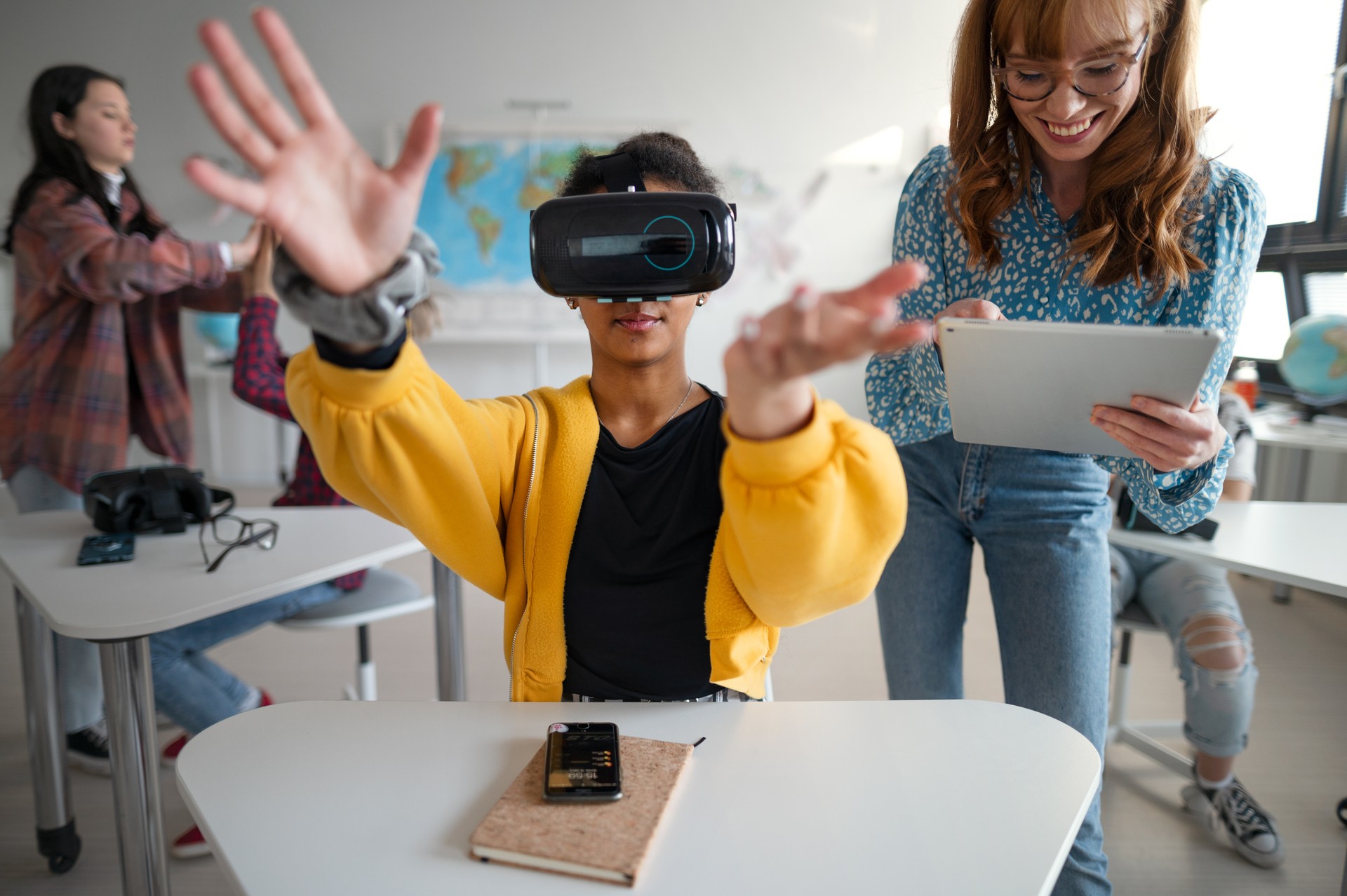 Teenage students wearing virtual reality goggles at school in computer science class